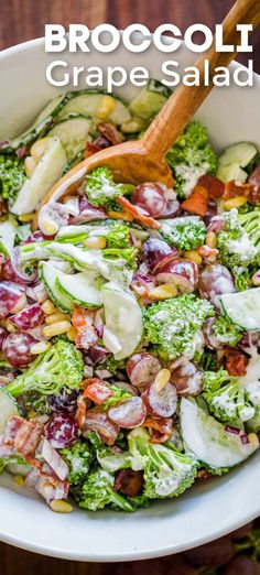 broccoli and grapes salad in a white bowl with a wooden spoon on the side