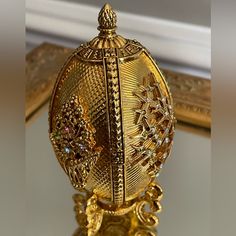 an ornately decorated golden egg sitting on top of a table