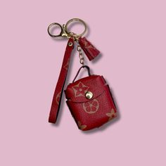 a red purse keychain hanging on a pink background