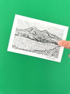 Baie de Fort de France et Pitons du Carbet - série Lines - Paysages nature mer Martinique par Intercalée - Dessin stylisé au trait - design abstrait original - reproduction signée format carte postale devant mur vert 
#art #martinique #souvenir #cadeau #decorationmurale #monochrome