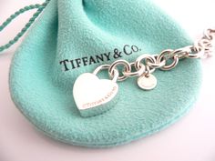 Offered for sale is a wonderful and rare Tiffany and Co. Sterling Silver "Love Match" Heart Padlock bracelet. The piece is made from substantial and bright Tiffany silver, and yet retains a very feminine feel to it. Attached to its very substantial Tiffany Silver charm bracelet is a Heart padlock charm with "Love Match" engraved on it. The"Love Match" padlock charm opens and closes and thus can be used as a charm on a necklace or as part of another charm bracelet! Super versatile piece! It is a Luxury Heart-shaped Bracelet For Wedding, Luxury Heart Bracelet For Wedding, Luxury Heart Charm Bracelet Gift, Luxury Sterling Silver Heart Bracelet For Gift, Luxury Wedding Heart Bracelet With Heart Charm, Luxury Heart-shaped Bracelet For Valentine's Day, Luxury Heart Bracelet For Valentine's Day Formal, Padlock Bracelet, Tiffany And Co Jewelry