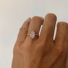 a person's hand with a diamond ring on it