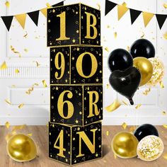 black and gold balloons are in front of a block with the number nine on it