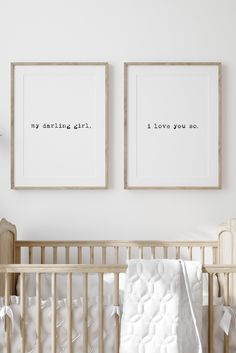 two framed pictures above a crib in a white room