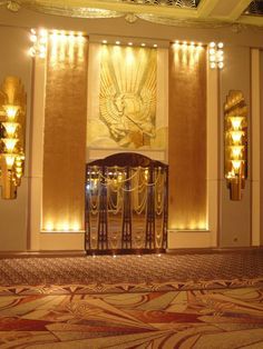 an ornate room with gold and white walls, chandeliers and decorative art on the wall