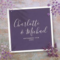 purple and white save the date sign with lavender flowers on a gray surface next to it