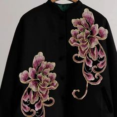 an embroidered black jacket with pink flowers on it