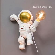 an astronaut doll is holding a light bulb