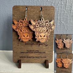 two wooden earrings with flowers on them and an image of a cow in the background