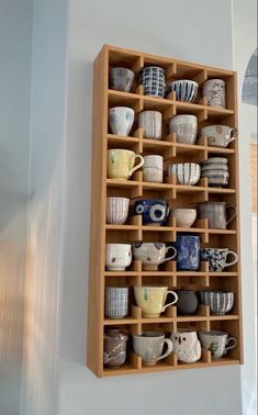 a wooden shelf filled with cups and saucers