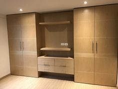 an empty room with wooden cabinets and drawers