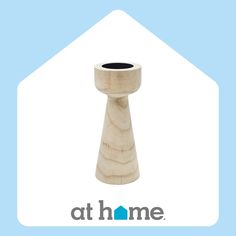 a wooden candle holder sitting on top of a blue and white background with the words at home written below it