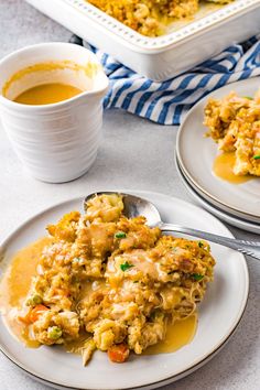 two white plates with food on them next to a bowl of soup and a spoon