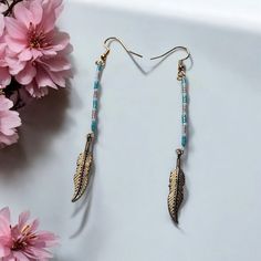 Elevate your style with these exquisite earrings featuring delicate feathers and intricate miyuki delica beads. The gold feather charms add a touch of elegance to these unique accessories, making them the perfect statement piece for any outfit. Handcrafted with attention to detail, these earrings are sure to turn heads and make you stand out from the crowd. Adjustable Gold Feather Earrings, Turquoise Feather Earrings, Bead Earring, Miyuki Delica Beads, Accessories Making, Gold Feathers, Unique Accessories, Feather Charms, Delica Beads