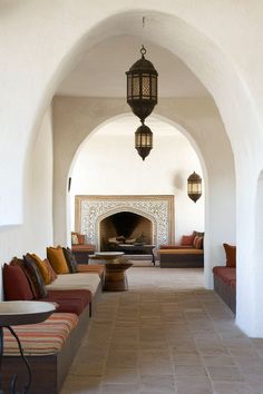 a living room filled with lots of furniture and a fire place in the middle of it