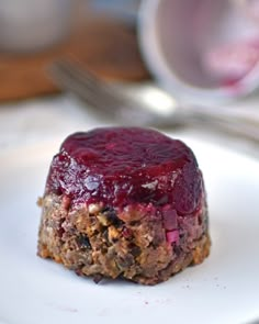 a piece of cake sitting on top of a white plate next to a fork and spoon