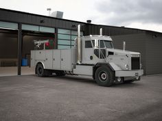 a large white truck parked in front of a building