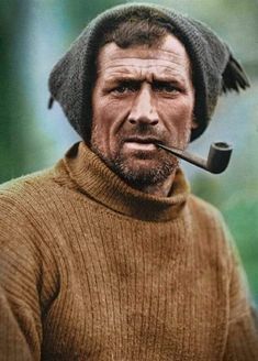 a man with a pipe in his mouth wearing a knitted hat and brown sweater