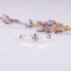 a close up of a ring on a table with lavender flowers in the foreground