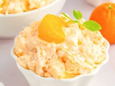 two bowls filled with food next to oranges