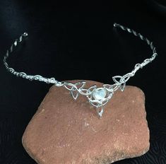 a stone with a silver necklace on top of it