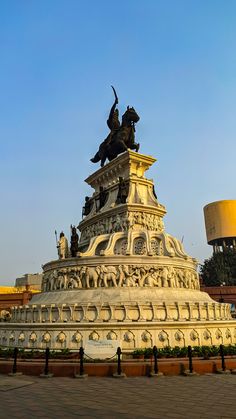 a large white monument with statues on it's sides and a lamp in the background