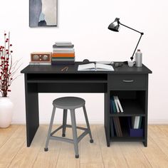 a computer desk with a chair and books on it