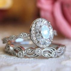 two wedding rings with an oval diamond in the center