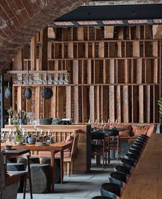 the interior of a restaurant with wooden walls and tables, chairs, and wine glasses