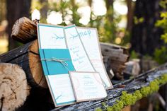 the wedding stationery was placed on top of logs