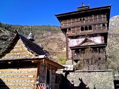 an old wooden building sitting next to a mountain