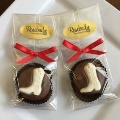 two chocolates wrapped in cellophane and tied with red ribbon