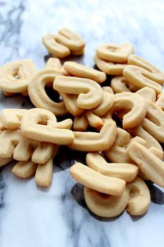 a pile of cookies sitting on top of a marble counter covered in frosted pretzels