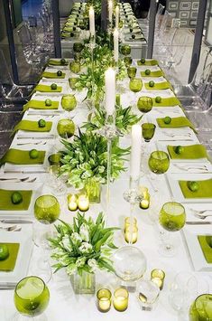 a long table with green place settings and candles