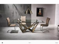 a glass table with chairs around it in front of a gray wall and painting on the wall