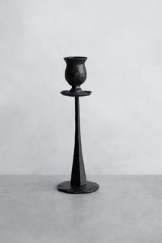 a black candle holder sitting on top of a table