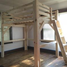 a loft bed made out of wooden planks in a room with hard wood flooring