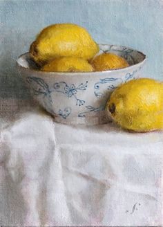 a painting of two lemons in a blue and white bowl on a tablecloth