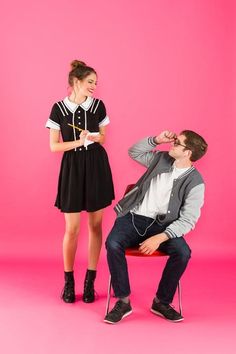 a man sitting on a chair next to a woman in a black and white dress