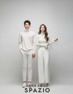 two people standing next to each other in white outfits