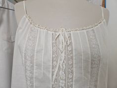 Small top in old lingerie style in fine cotton called batiste. It is a vintage fabric from the 50s. It is very soft and smooth and incredibly light. In the center, two embroidered bands separated by Valenciennes lace with Art Deco patterns, which highlight the embroidery. One size fits all from 36 to small 38 Chest circumference -100 cm Height -50 cm Unique piece, entirely handmade! Thank you for reading my ad. Sleeveless Cotton Camisole With Lace, Summer Wedding Tops With Delicate Straps, Vintage Tops For Summer Weddings, Delicate Camisole Tops For Summer, Delicate Summer Camisole Top, Delicate Fitted Camisole For Summer, Vintage Summer Tops With Lace Work, Delicate Sleeveless Summer Tops, Delicate Summer Daywear Camisole