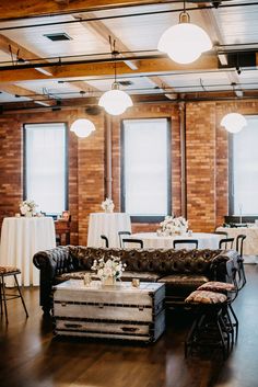 a living room filled with lots of furniture and tables covered in white tablecloths