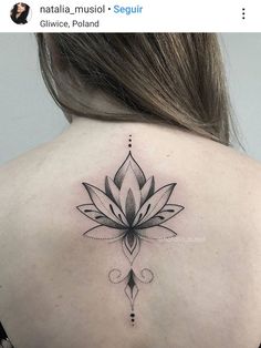 the back of a woman's neck with a lotus tattoo on it