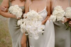 the bridesmaids are holding bouquets of white flowers in their hands and wearing gray dresses