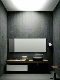 a bathroom with a sink, mirror and stool next to the wall in front of it