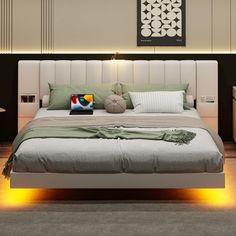 a large bed with pillows and blankets on it in a room that is lit up