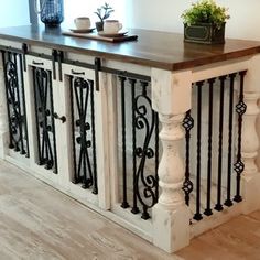 a kitchen island with wrought iron railings on the sides and a potted plant on top