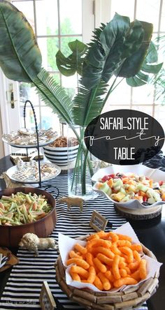 a table topped with lots of food next to a potted green plant and window