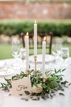 a table topped with white flowers and candles