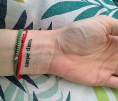 a woman's hand with a red bracelet that says, keep calm